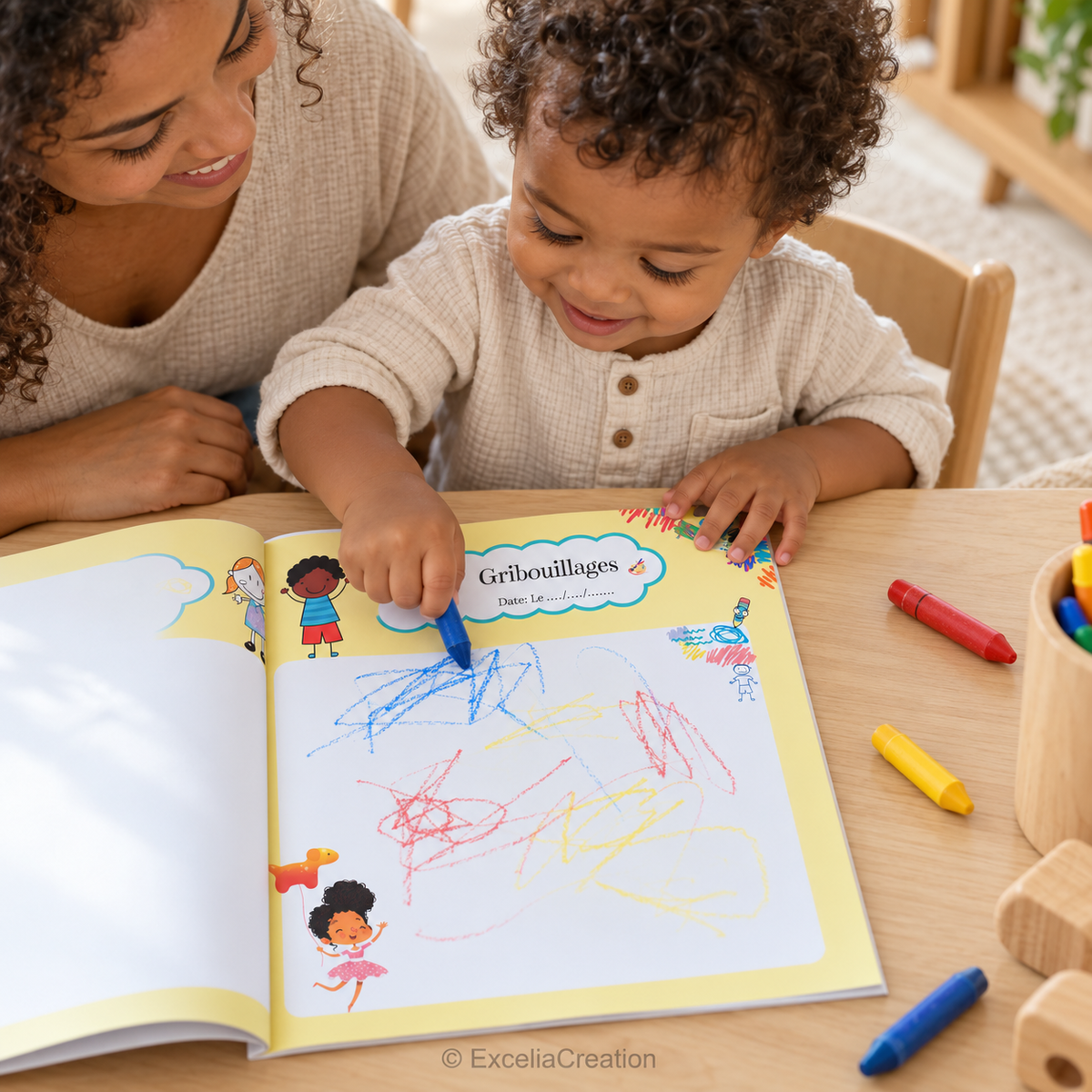 Un tout-petit gribouille dans son cahier avec sa maman